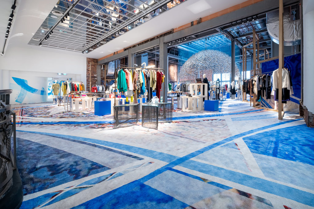 Art urbain au Printemps Haussmann – des lignes bleus superposées sur un immense tapis persan