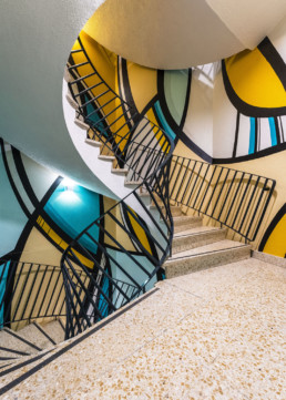 Fresque urbaine dans la cage d’un escalier en colimaçon