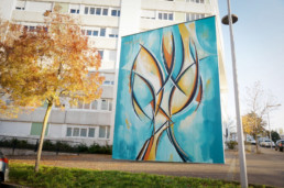 Fresque urbaine aux tons lumineux représentant un arbre stylisé